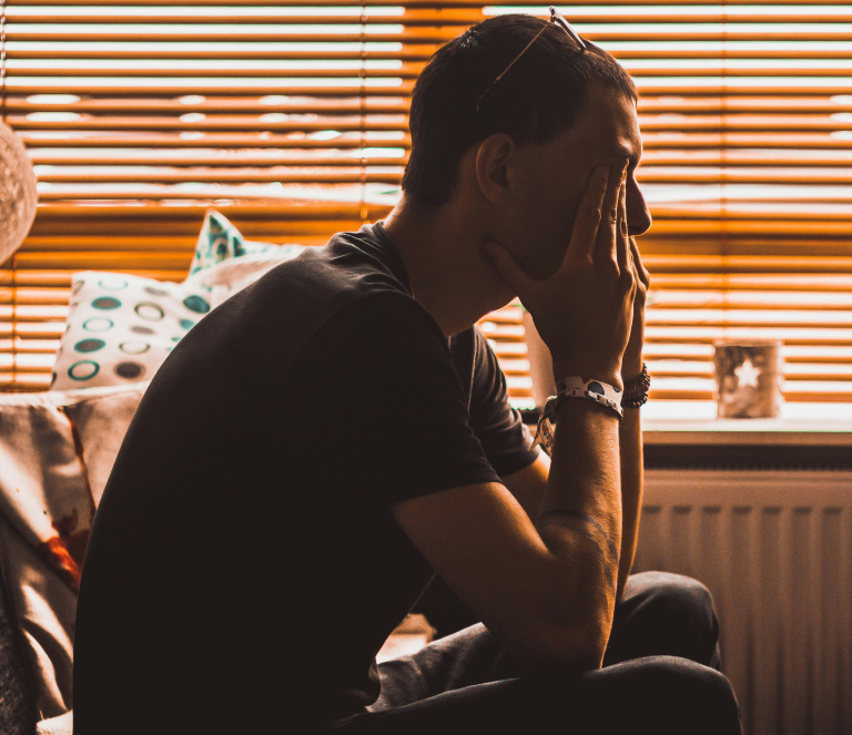 Man sitting rubbing face