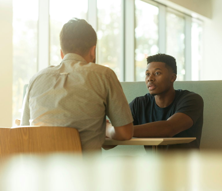 Two men sitting at table talking